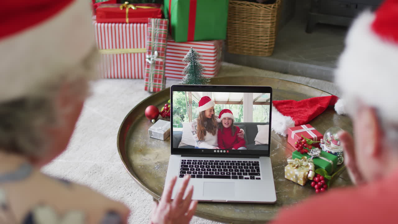 pareja caucásica de alto nivel usando una computadora portátil para una videollamada de navidad con familia feliz en la pantalla