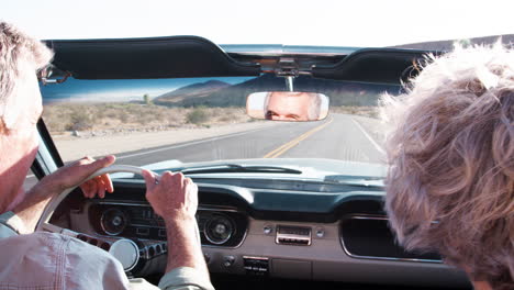 Senior-couple-driving-old-convertible,-back-view,-close-up