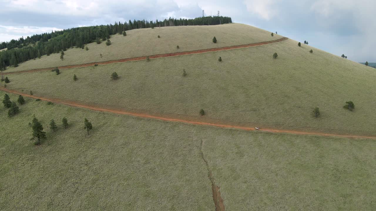 vista aérea de un camión que sube por la carretera en zigzag de la montaña green peak
