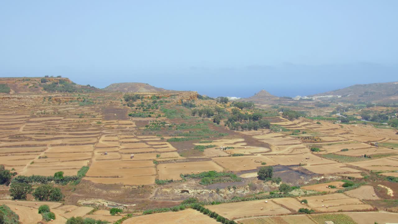 Vasto terreno agricolo sotto un clima caldo e arido vicino alla campagna