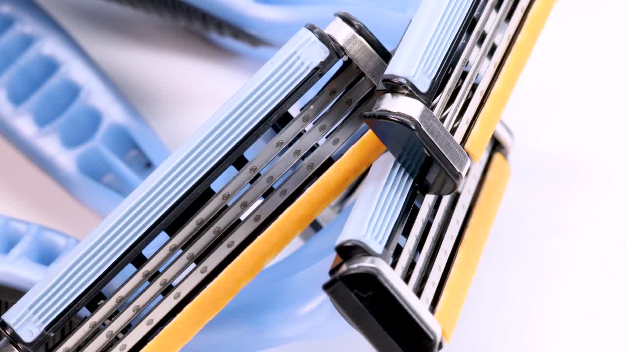 흰색 배경에서 회전하는 일회용 면도기 면도날, 4k의 매크로 샷