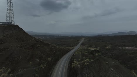 aerial drone footage following a car driving through a mountain landscape in balochistan