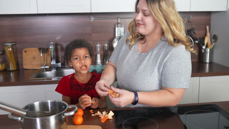 madre e hija pelando naranjas en la cocina