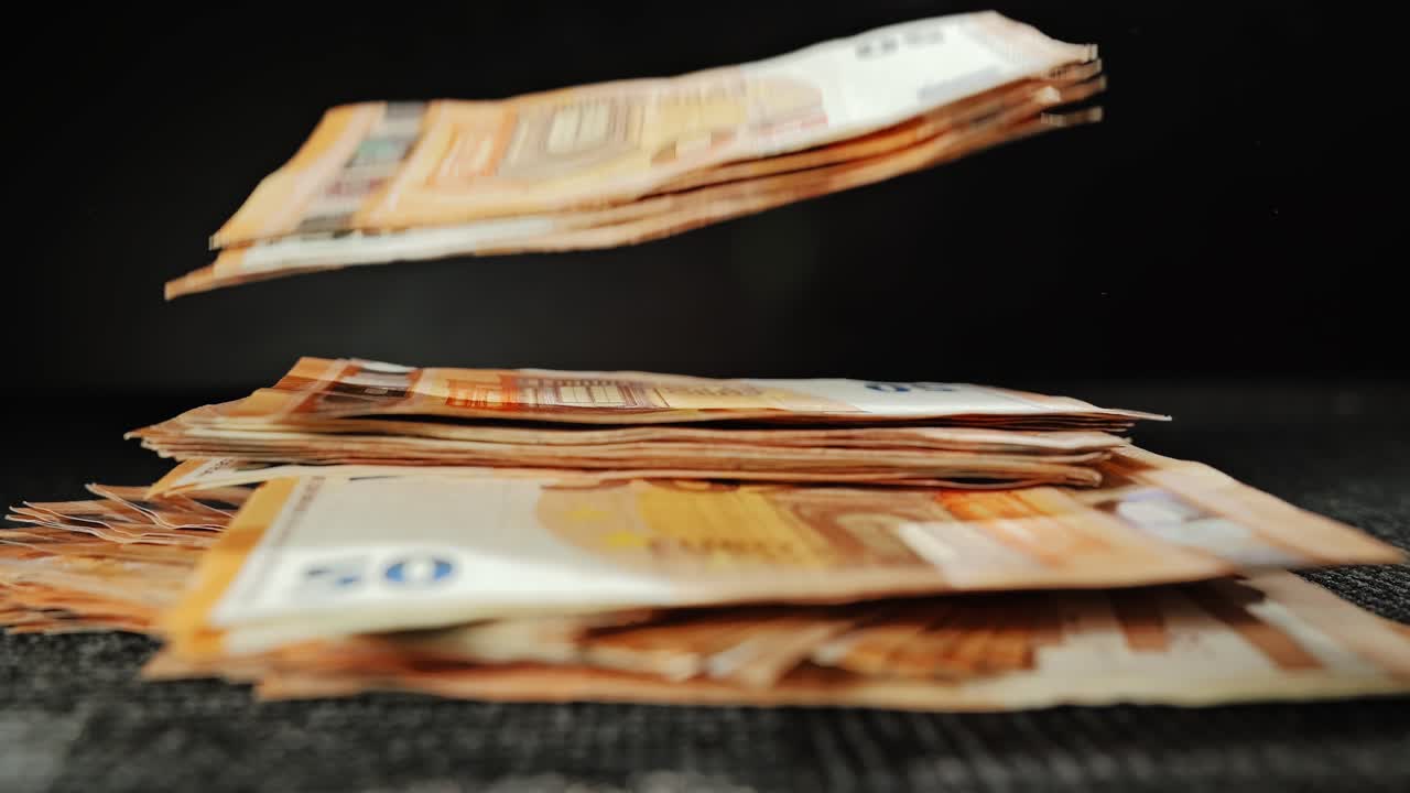 Fünfzig-Euro-Scheine, die in Zeitlupe auf einen dunklen Teppich fallen, ESG-Anlagethema