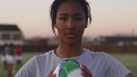 portrait of young adult female rugby player on a rugby pitch