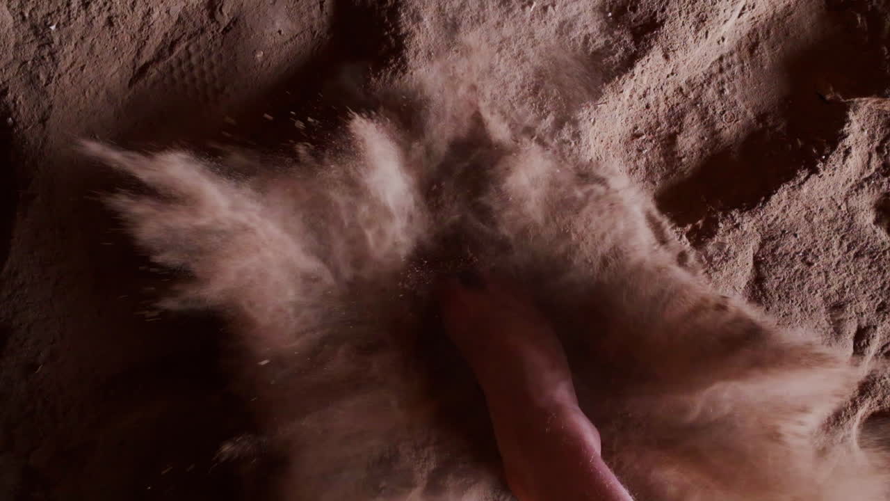 Bare foot hits the sandy floor. Slow motion