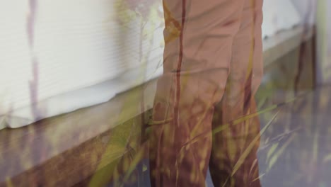 animation of grass over legs of african american boy