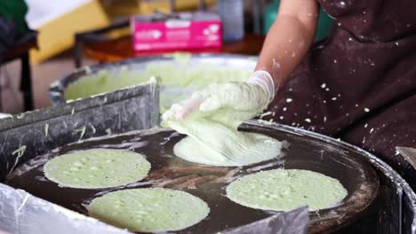 preparing and cooking green crepes on hot griddle