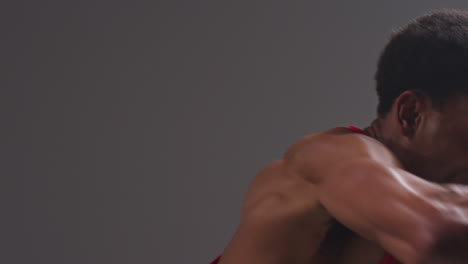 Close-Up-Studio-Shot-Of-Male-Boxer-Wearing-Boxing-Gloves-In-Boxing-Match-Throwing-Punches-Against-Grey-Background-1