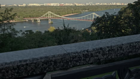 camera rises to reveal the dnipro pedestrian bridge on a a warm autumn evening in kiev