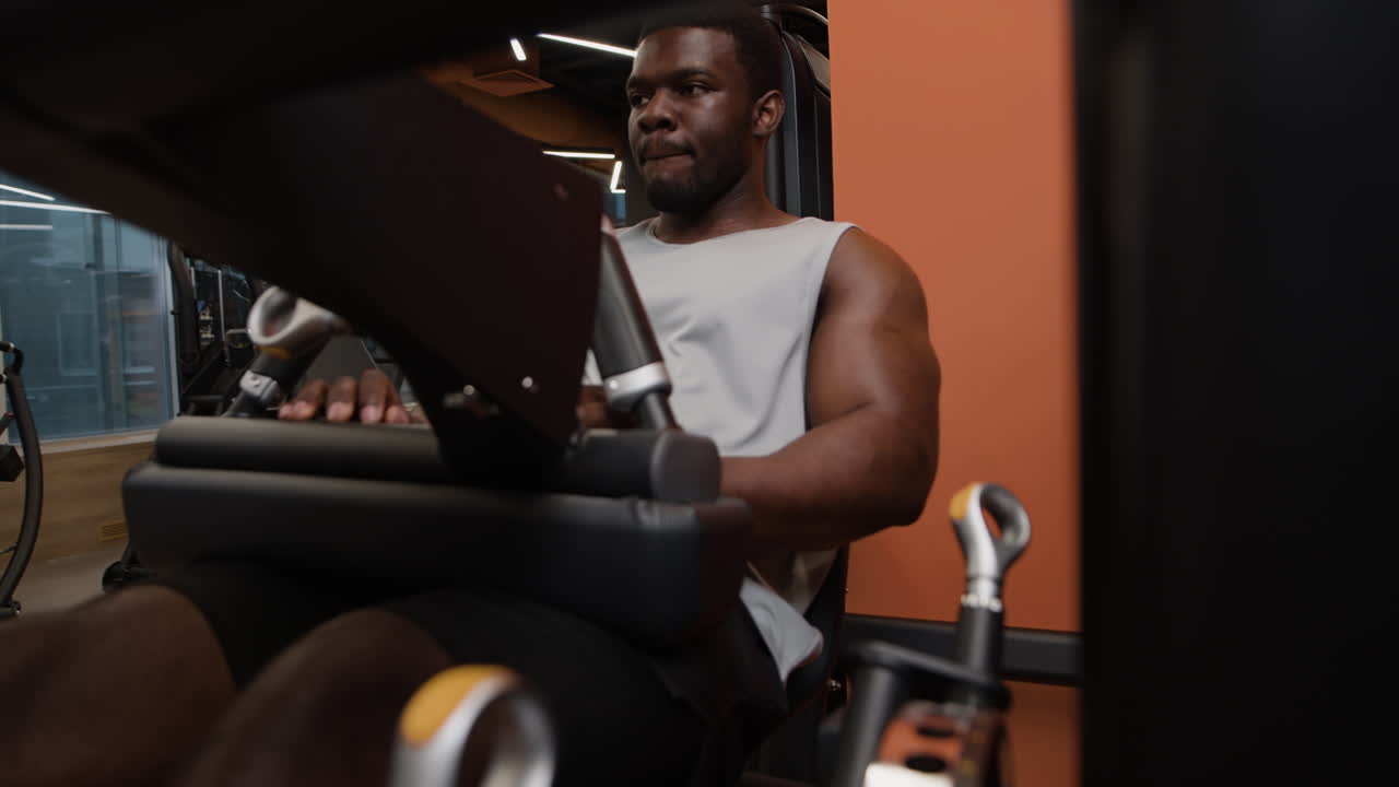 hombre trabajando en la máquina de prensa de piernas en el gimnasio