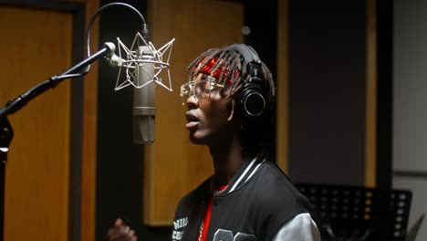 man singing into microphone in recording studio