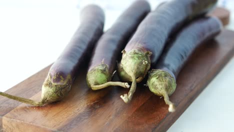 fresh eggplants on a wooden cutting board