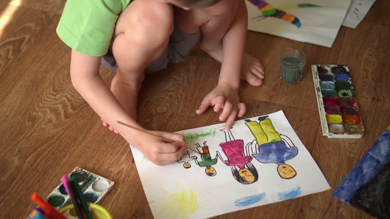아이가 바닥에 수채화로 그림을 그린다. - 가족을 묘사하는 그림 02