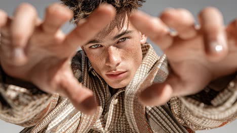 freckled model framing face with hands in slow motion