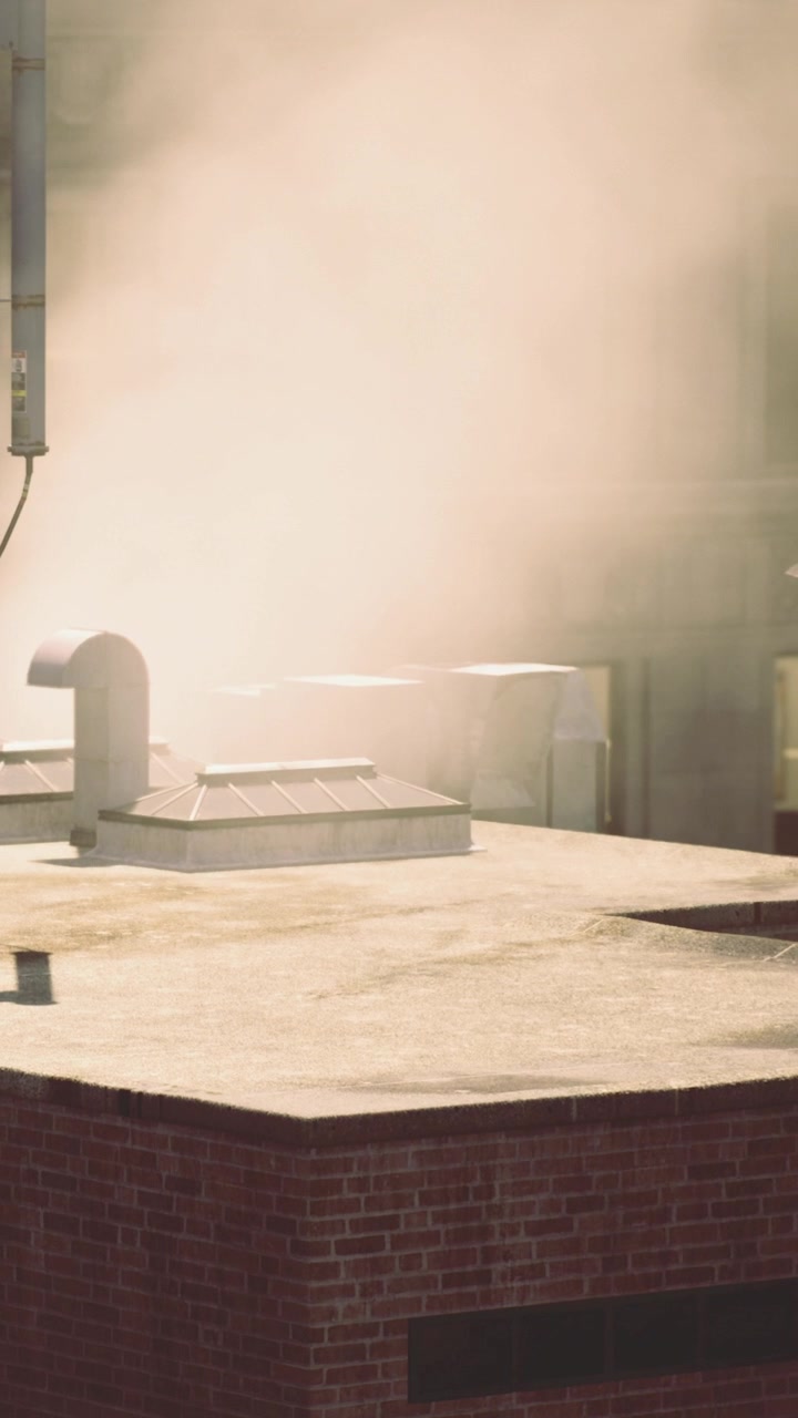 Steam rises from rooftop in city during sunny afternoon in summer
