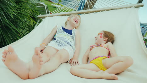 Two-Naughty-Girls-Ride-On-A-Hammock-Made-Of-Fabric-In-The-Seaside-Resort