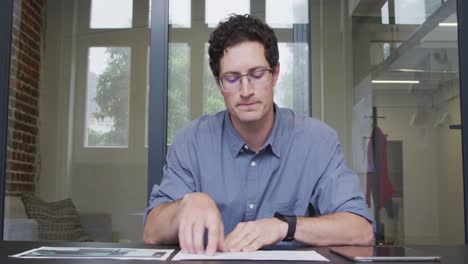 Portrait-of-man-reading-a-document-at-office