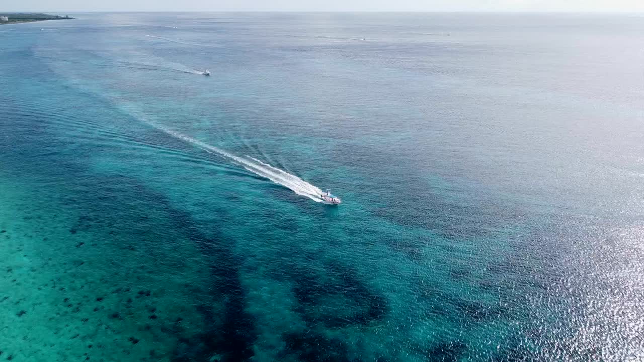 vista aérea de un pequeño bote creando una estela en el mar caribe