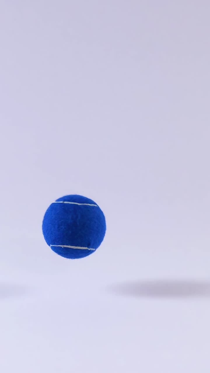 A blue tennis ball bounces repeatedly