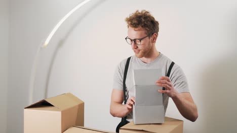 Young-handsome-man-happily-browses-the-boxes-with-products