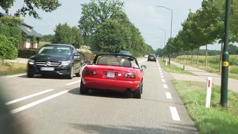 紅色 cabriolet 汽車在荷蘭的道路上行駛