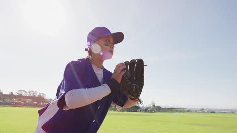 mixed race female baseball fielder catching and throwing ball on the field