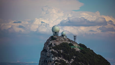 radar de vigilancia meteorológica en la parte superior de la roca de gibraltar con nubes que fluyen detrás