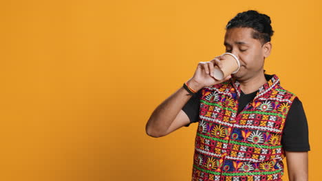 tired man drinking coffee, isolated over studio background