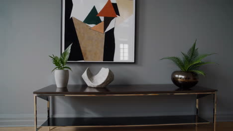 modern interior with console table, abstract art, and greenery