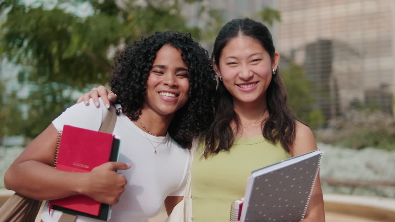 Asian and African-American female students with notebooks and books