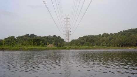 lake mountain and electricity tower high voltage power line electric transmission tower and flow ing water