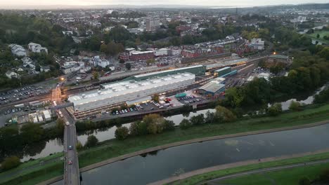vuelo de drones aéreos temprano en la mañana sobre la estación de tren de exeter saint david y vistas de la ciudad aérea hacia atrás reveladas antes del amanecer, incluido el río exe y el canal de inundación