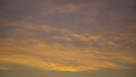 Tiro-De-ángulo-Bajo-De-Nubes-Gruesas-Que-Pasan-En-Timelapse-Con-Rayos-Amarillos-A-Lo-Largo-Del-Sol-Poniente