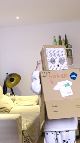 child dancing in funny cardboard robot costume. humorously homemade robot costume crafted from cardboard boxes and paper. playful scene set in cozy living room. modern decor, plants, and stylish lamp.