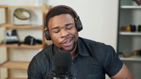 a black man charismatically records his conversation on a microphone