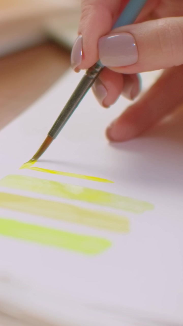 Artist Painting Yellow Watercolor Swatches on Paper