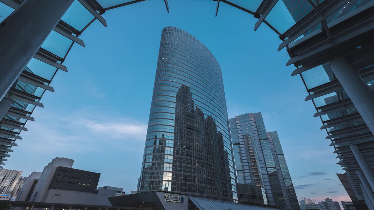 timelapse de nubes y luces encendidas en un moderno edificio de la torre de tokio