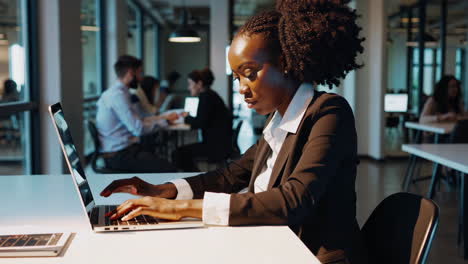 woman working on laptop in a modern office environment