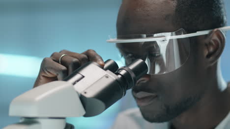 African-American-Scientist-Looking-through-Microscope-in-Lab