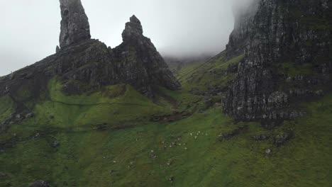 Aerial-drone-view-of-old-man-of-storr-in-isle-of-Skye-scotland,-green-landscape-during-a-cloudy-day