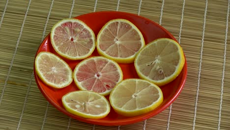 rebanadas de limón frescas girando en un plato rojo