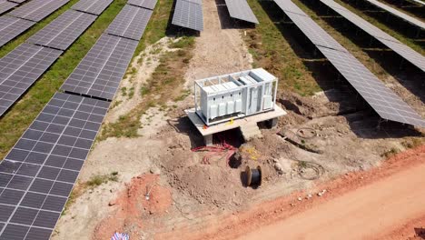 aerial reverse plus tilt up view of medium voltage solar inverter station and cabling reel during installation