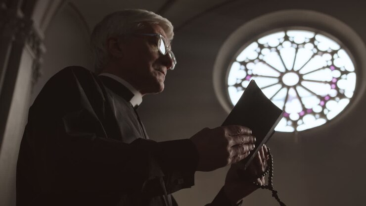 Sacerdote anziano che prega in chiesa
