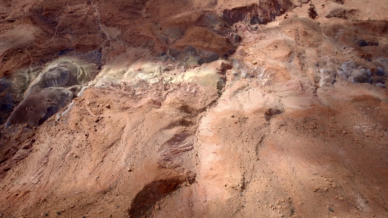 Dramatic and artistic drone shot looking down on canyon and desert floor from above, full of abstract colors and design