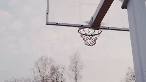 camera focuses on ball falling into the basketball hoop