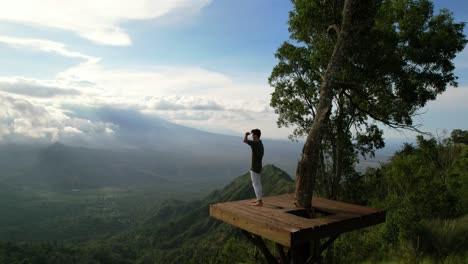 man at lahangan sweet viewpoint tourist attraction on sunny day in bali, aerial