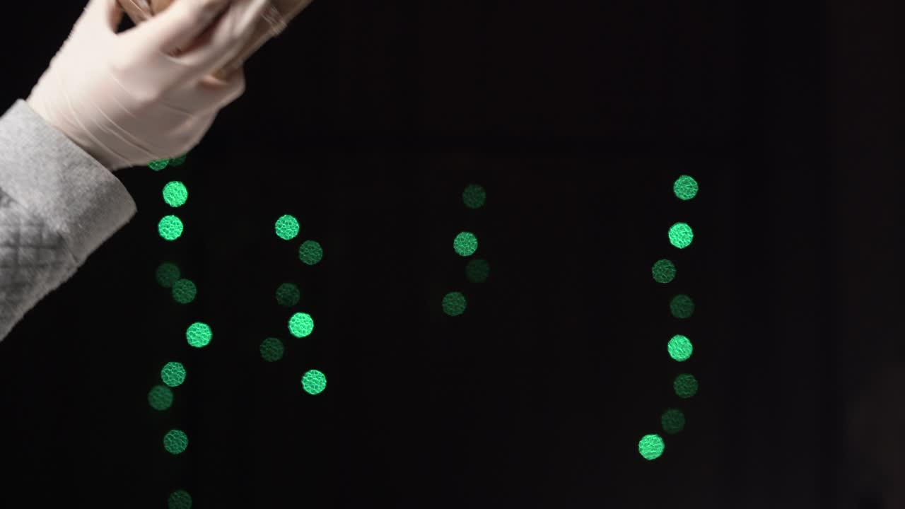 의료 장갑을 입은 남성의 손은 공예 종이로 감싸진 상자를 줍니다.