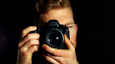close-up of male photographer photographing with digital camera