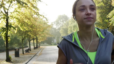 runner woman running in park exercising outdoors fitness tracker wearable technology